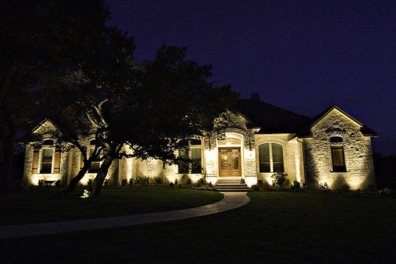 Front of house lit up by landscape lighting at night
