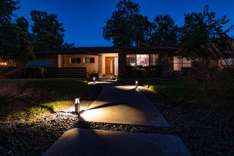 Pathway lit by in-ground lights at night