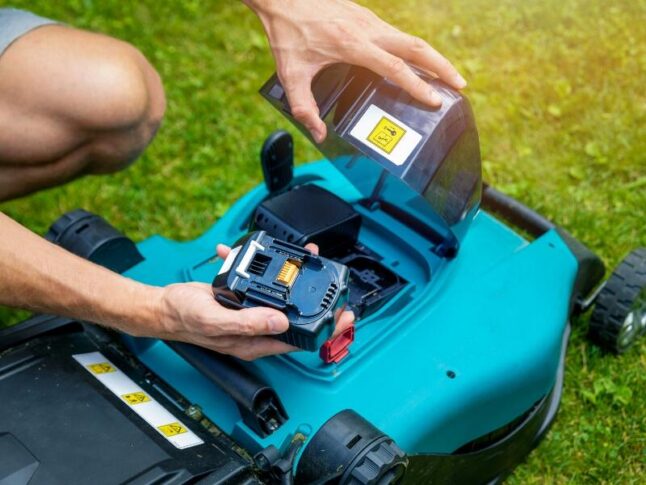 man replacing lawn mower battery
