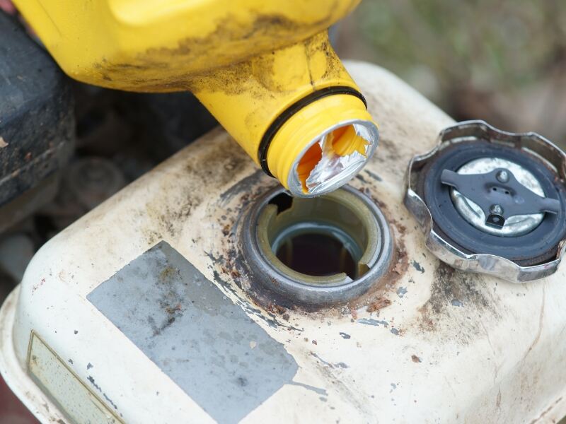 motor oil bottle above lawn mower oil cap