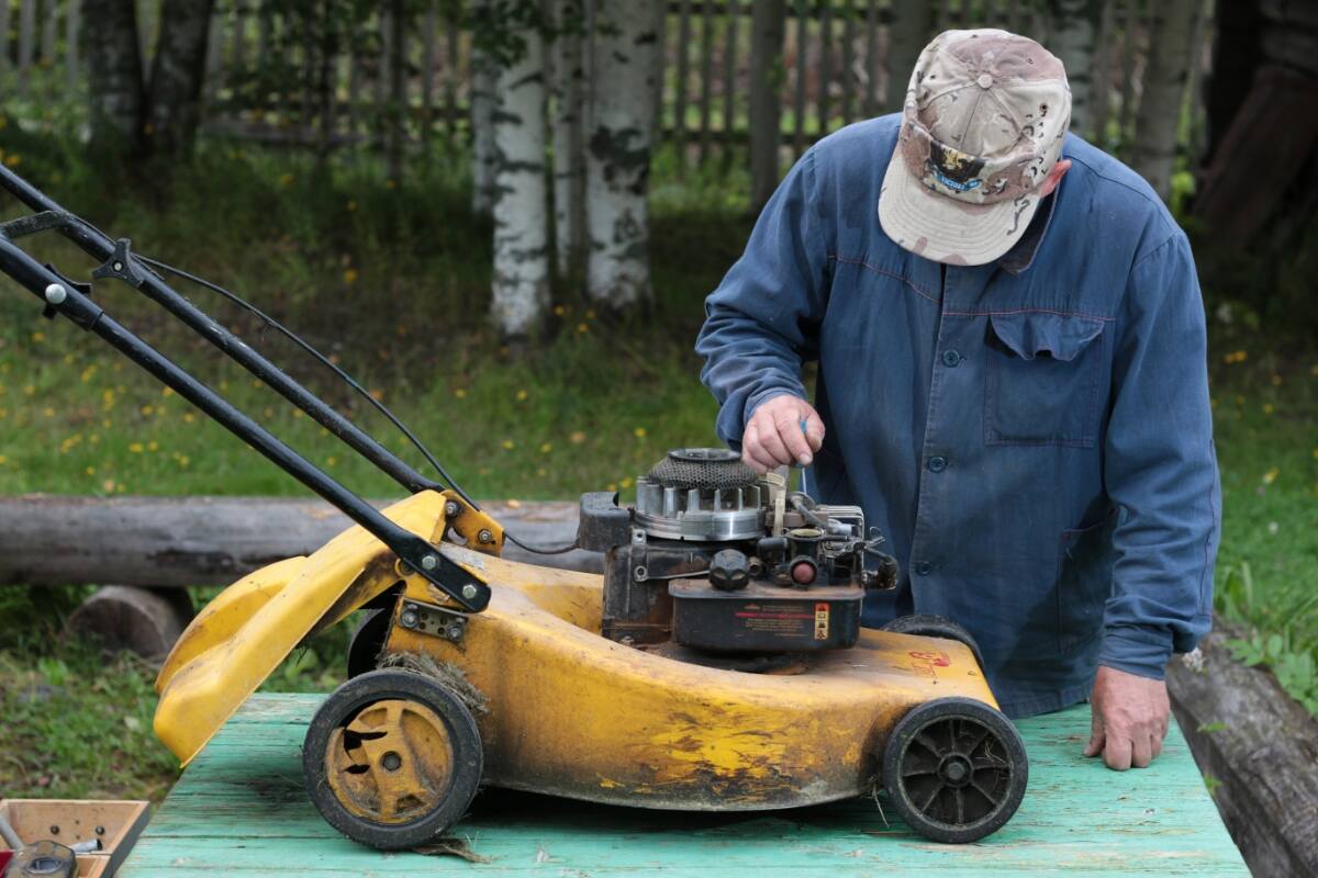 man repairing a lawn mower