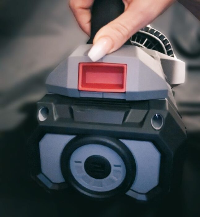 person holding a leaf blower with a Red quick release button 