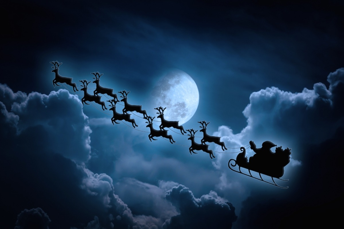 silhouette of Santa and his reindeer flying through the night sky