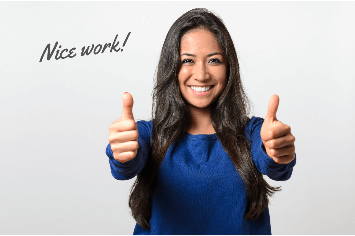 A smiling woman in a blue sweatshirt gives two thumbs up with the word “Congrats” in the upper left.