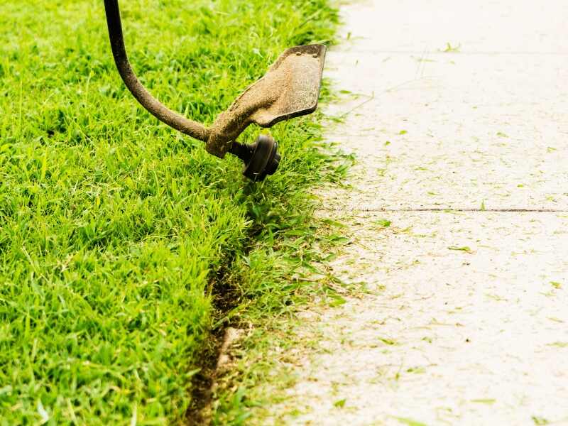 edging a sidewalk with a string trimmer