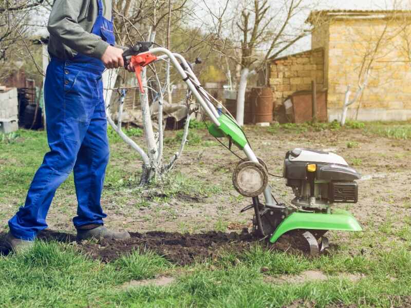 man tilling the soil with a rototiller