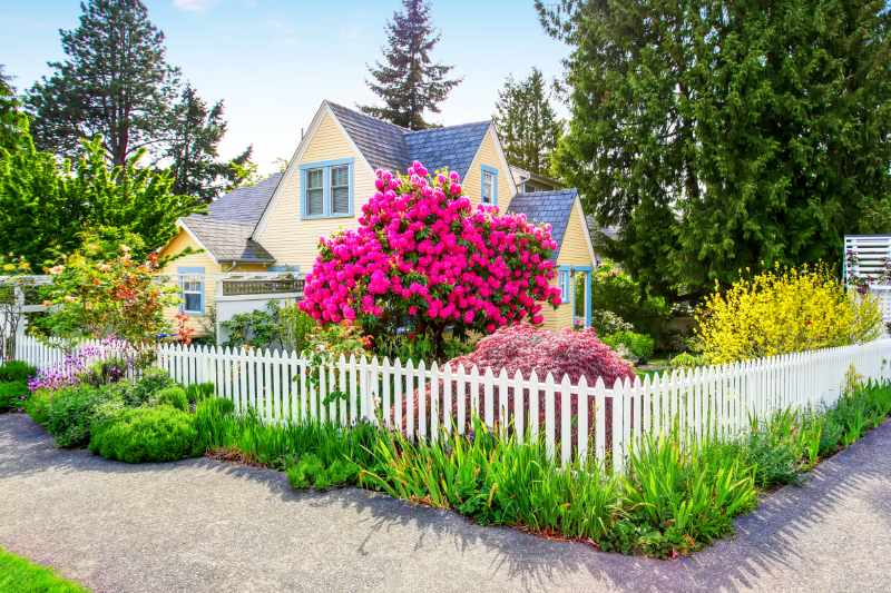small house exterior with white picket fence