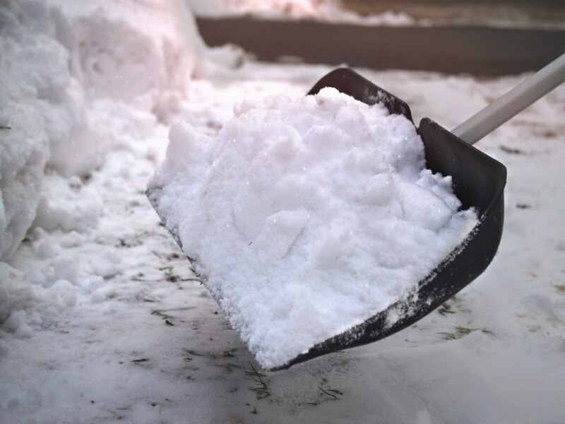 shoveling snow using a snow shovel