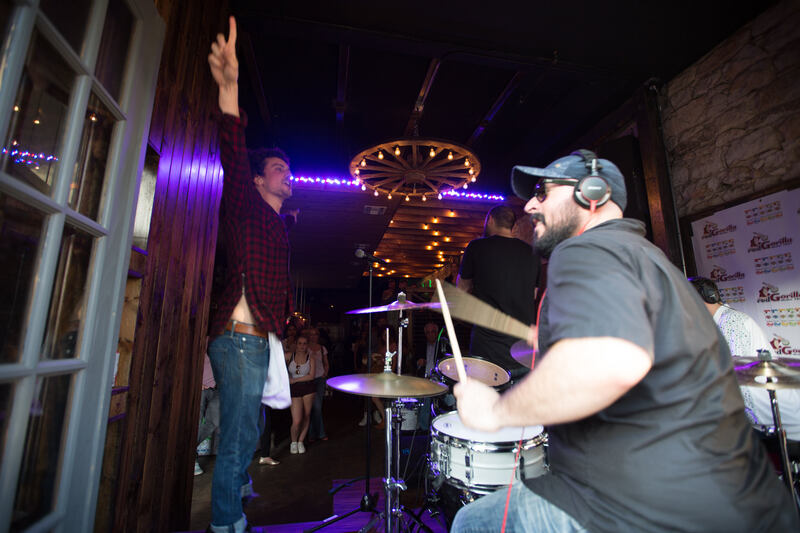 person beating a drum and singing at concert