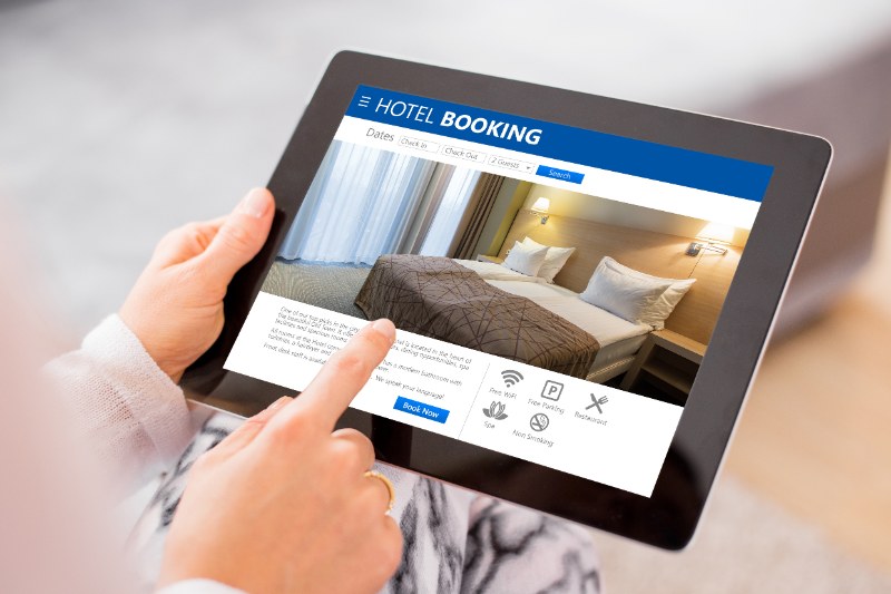 person booking hotel room on tablet