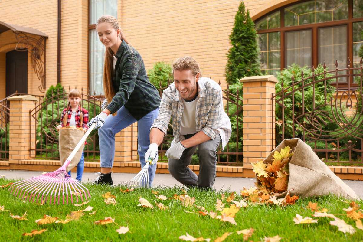 Family cleaning up autumn leaves outdoors