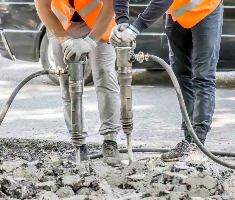 Workers removing concrete with jackhammers