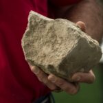 person holding compacted soil in his hand