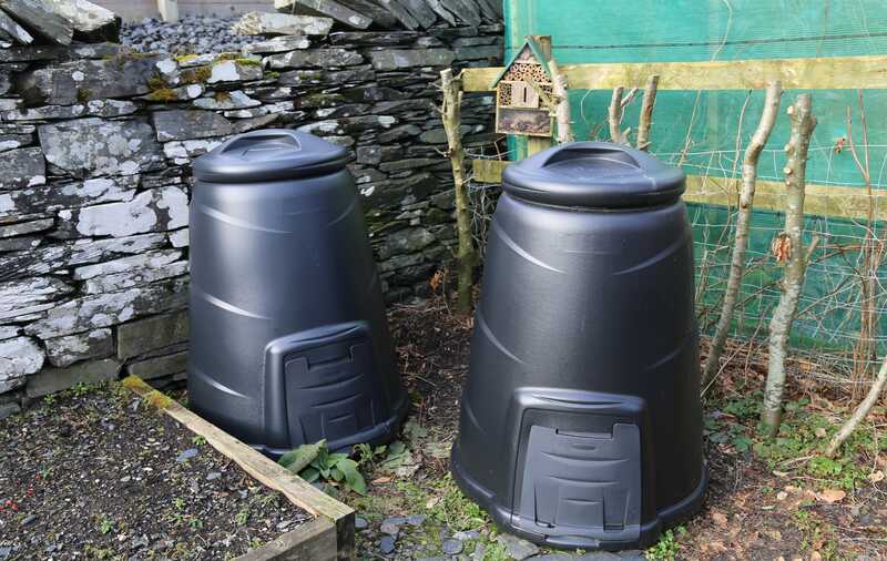 Two black compost bins in a winter vegetable garden