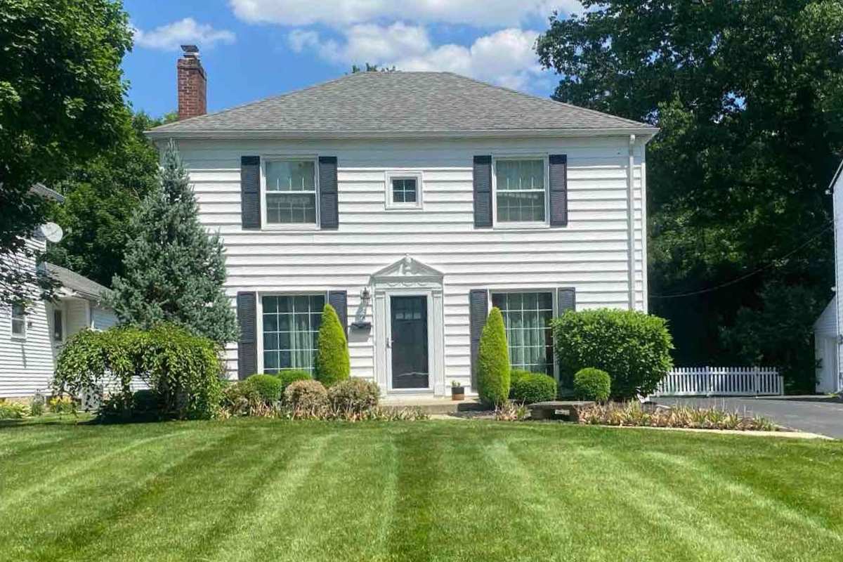 landscaped lawn in front of a house in Akron with a blue sky with clouds