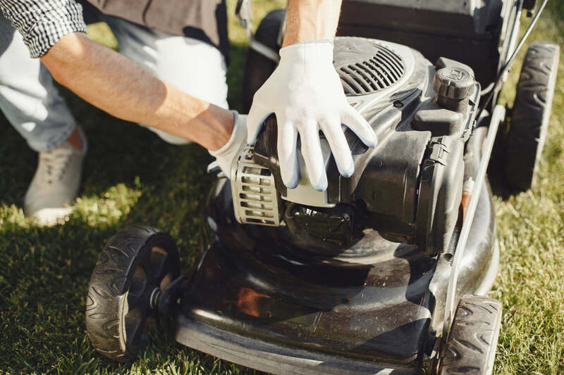 Man performing maintenance on lawn mower