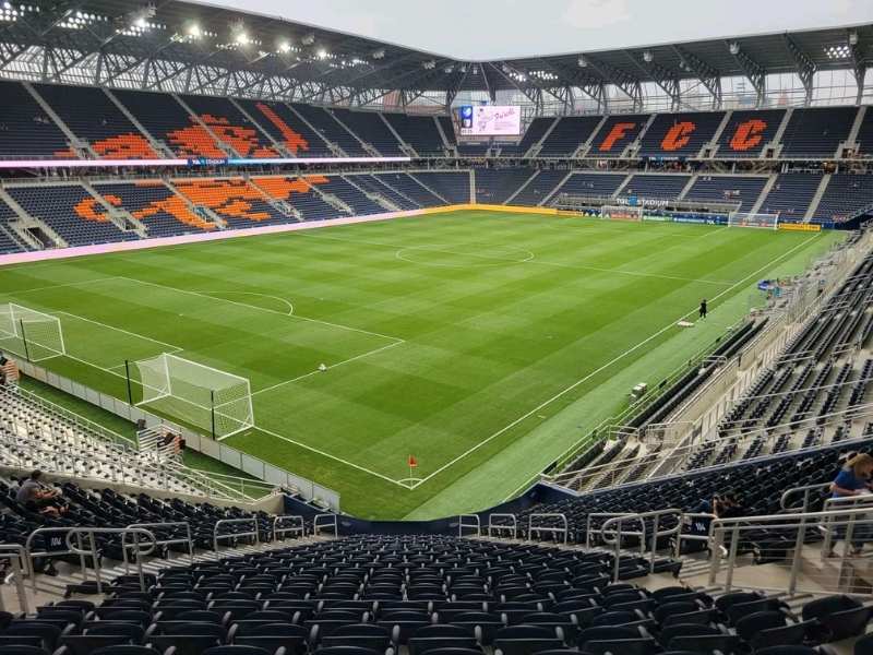Modern, empty soccer stadium with navy and orange seats, home to FC Cincinnati.