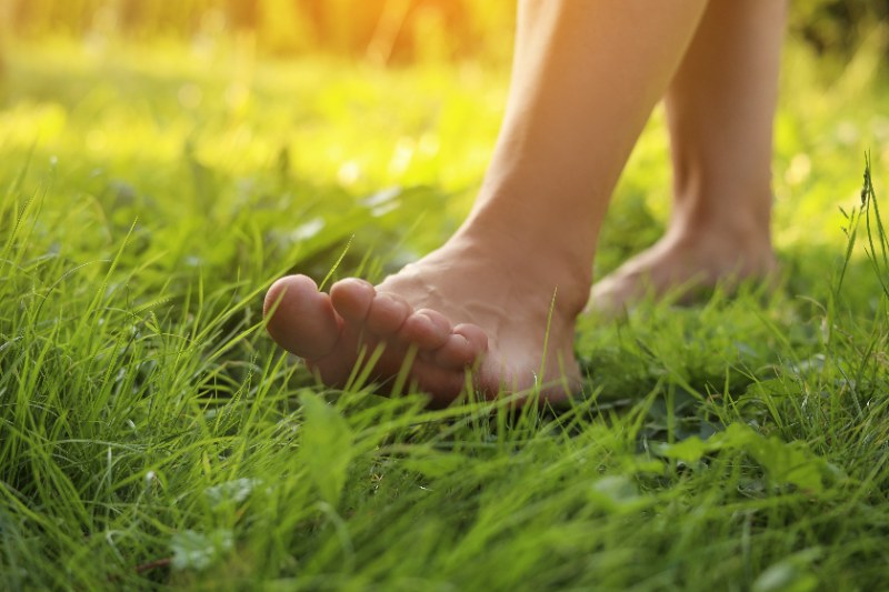 closeup of woman walking barefoot on green grass