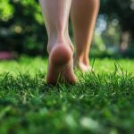 Close up of woman's bare feet walking over green grass