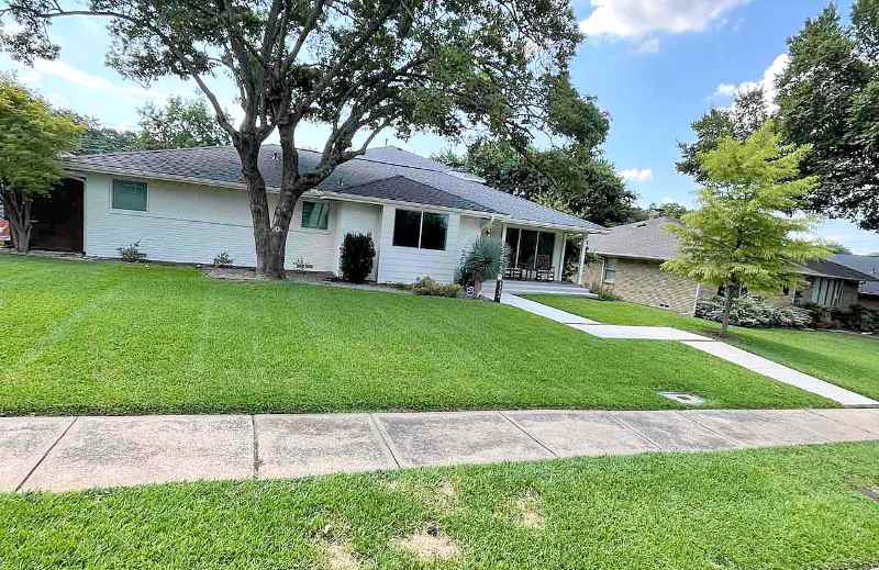 Well-maintained front lawn with neatly mowed grass in front of a house in Dallas, Texas.
