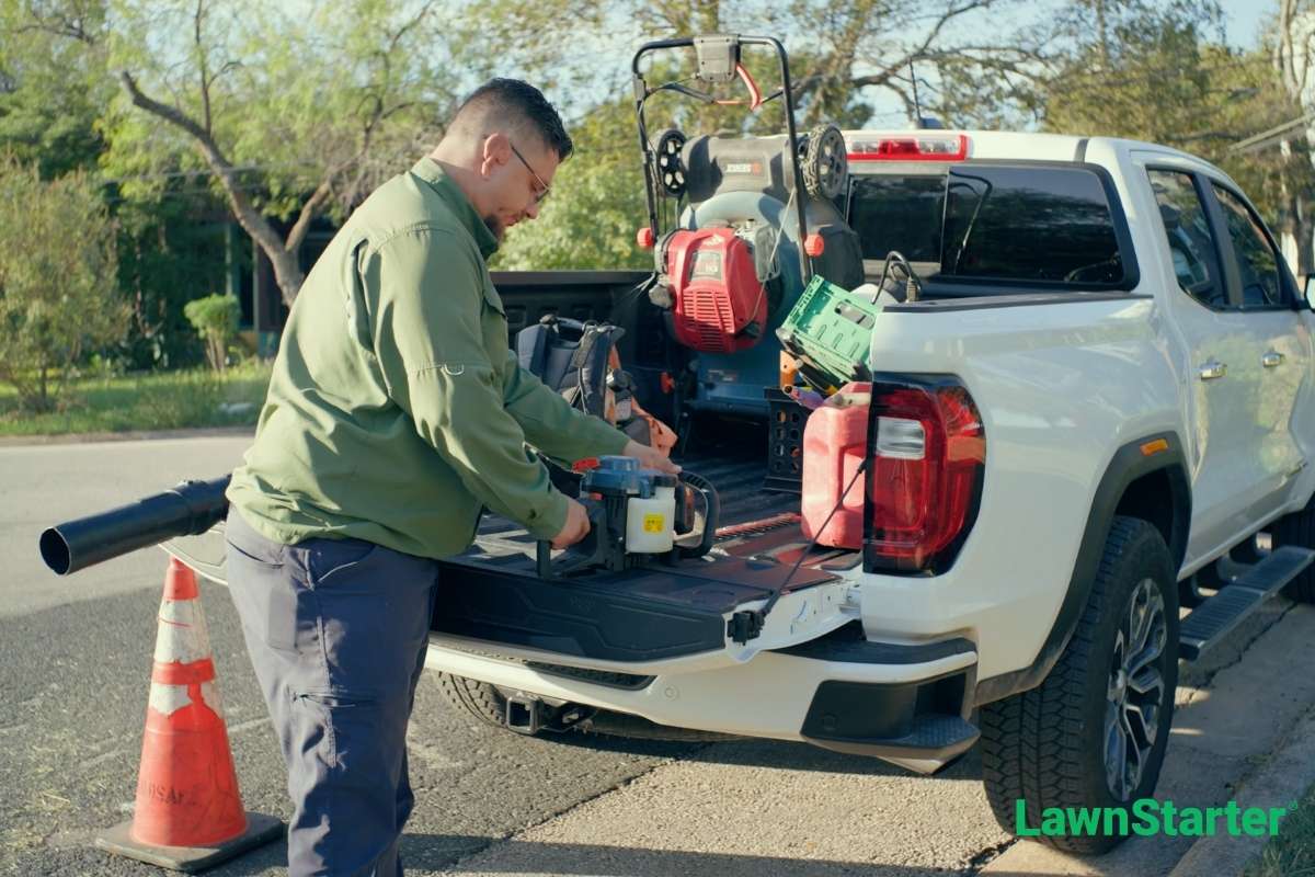Carlos Garza, LawnStarter pro and owner of NC Dip and Clip out of San Antonio TX, stands at the end of his truck to gather equipment.