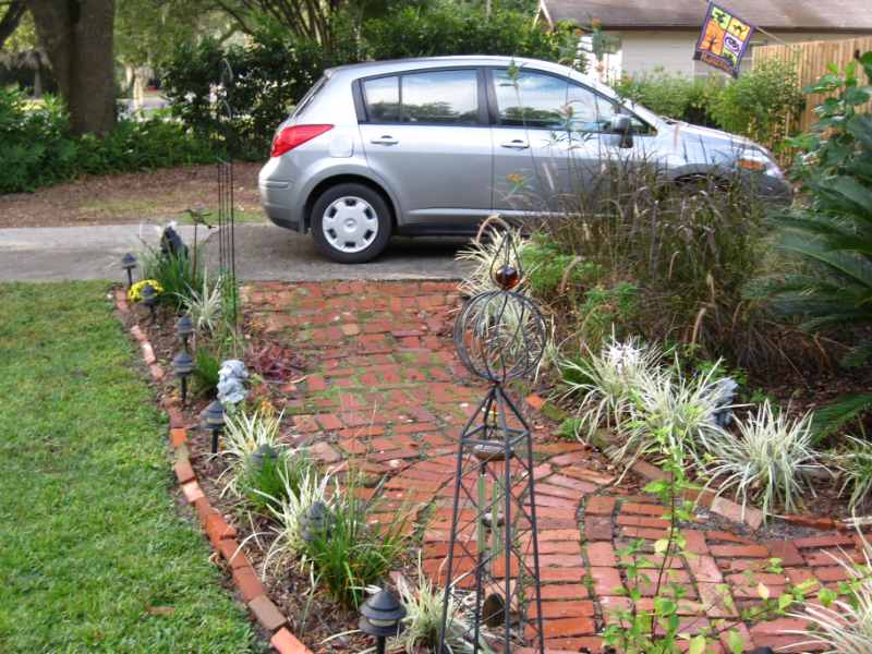 Brick walkway lined with landscaped plants